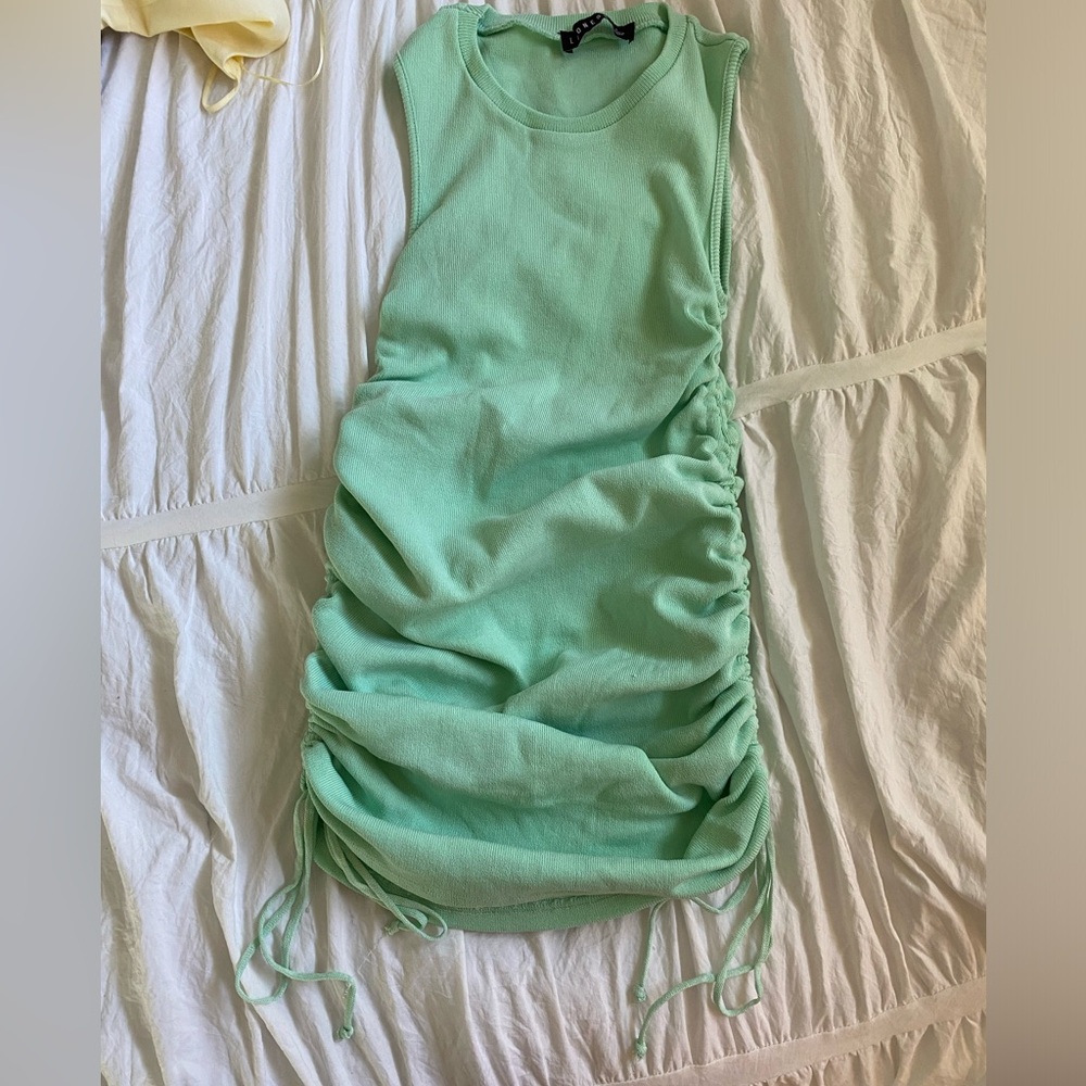 Cute mini light green dress with ties on the sides for adjustable lengths.
